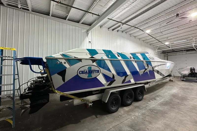 Slide: The Image of 2000 Cigarette 42' Tiger boat with geometric design in a garage setting. - 3