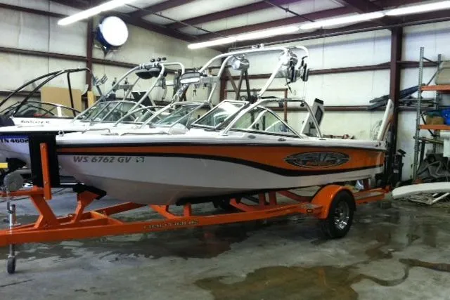 The Image of 2005 Nautique Air Nautique 206 boat in garage, orange trailer, wakeboard towers. - 0