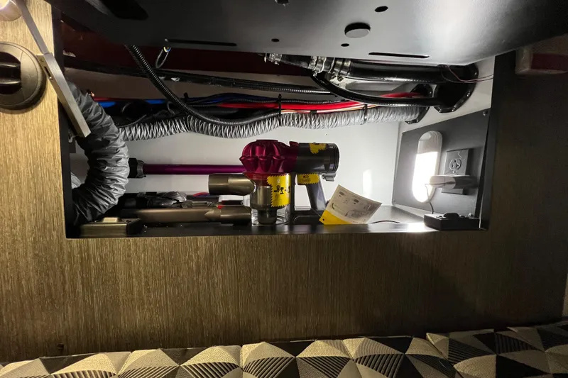Slide: The Image of Interior view of a 2023 Monterey 378SS Super Sport boat's storage compartment with equipment and wiring. - 30