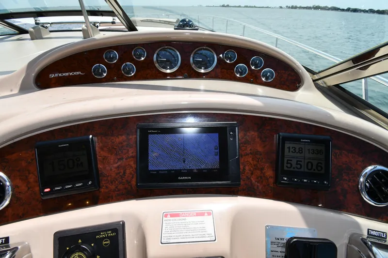 Slide: The Image of The dashboard of a 2000 Sea Ray Sundancer 460 with various instruments and a Garmin screen. - 16