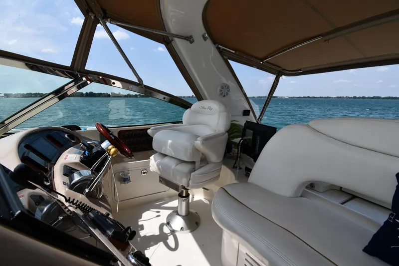 Slide: The Image of The cockpit of a 2000 Sea Ray Sundancer 460 with comfortable seating and a view of the water. - 19