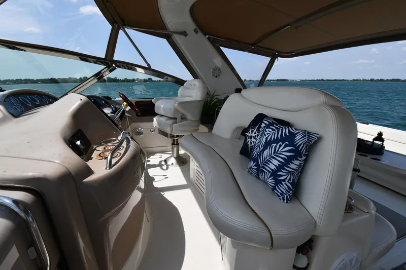 Slide: The Image of The image shows the cockpit of a Sea Ray Sundancer 460 with white leather seats and a blue pillow. - 21