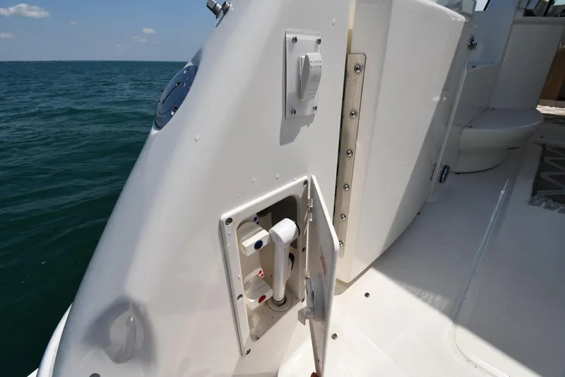 Slide: The Image of Close-up of a boat deck with access panel and switches, sea in the background. - 24