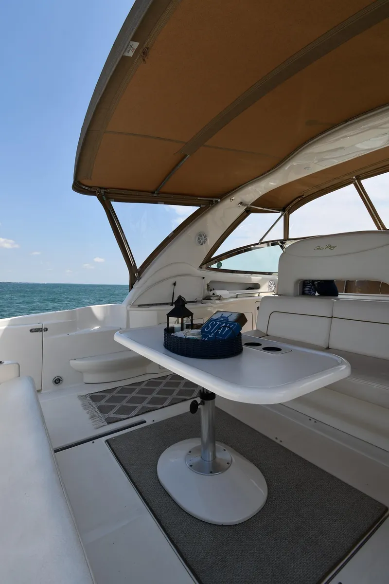 Slide: The Image of The image shows the cockpit of a 2000 Sea Ray Sundancer 460 with a table and seating. - 28