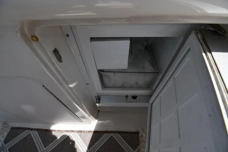 Slide: The Image of An open refrigerator or freezer on a boat with carpeted flooring. - 33