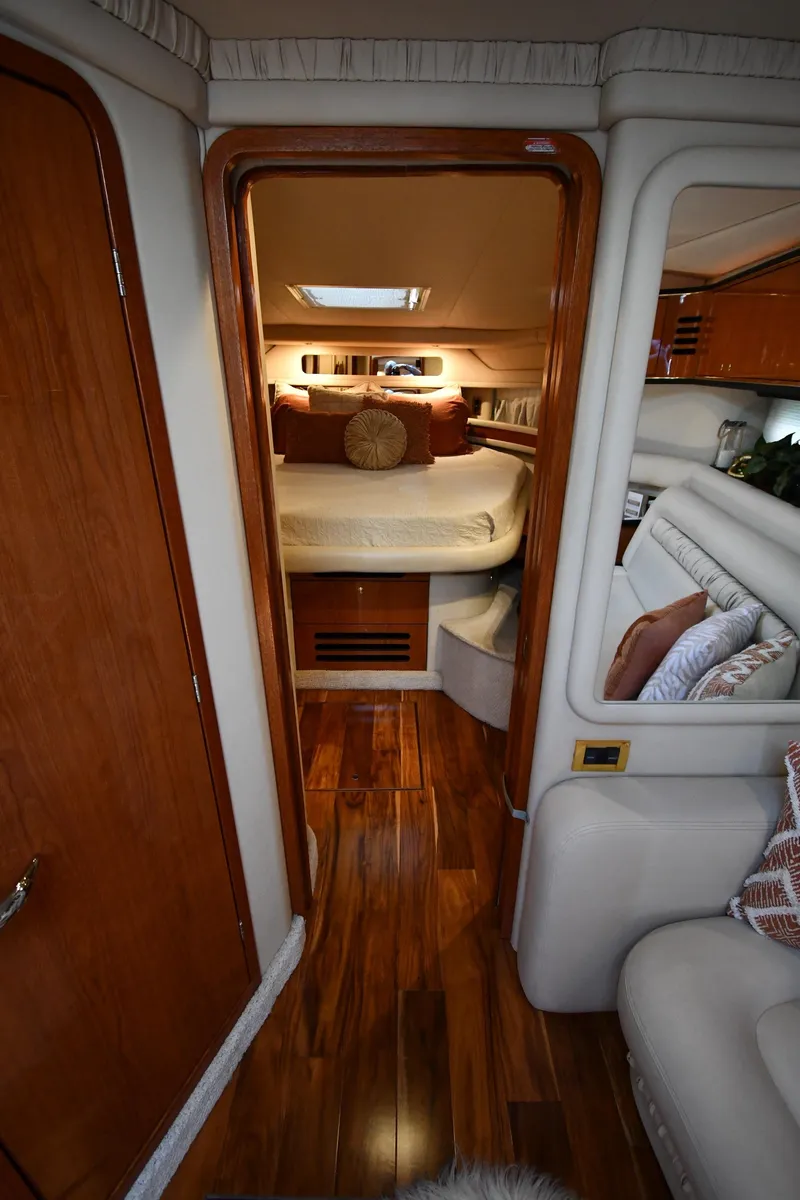 Slide: The Image of Interior of a 2000 Sea Ray Sundancer 460 with wooden flooring and a cozy bedroom. - 35