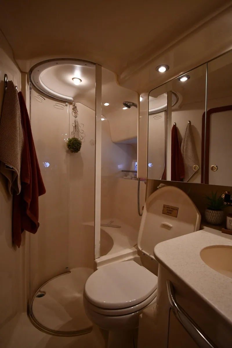 Slide: The Image of The image shows a boat bathroom with a shower, toilet, and sink. - 44