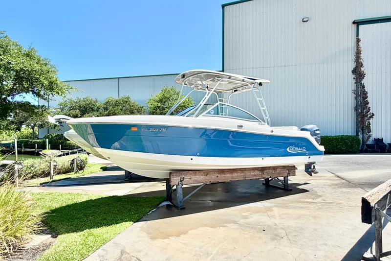 The Image of 2012 Robalo R247 Dual Console boat on display, blue and white exterior, outdoors. - 0