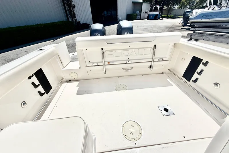 Slide: The Image of 2012 Robalo R247 Dual Console boat deck with storage compartments and twin engines. - 11