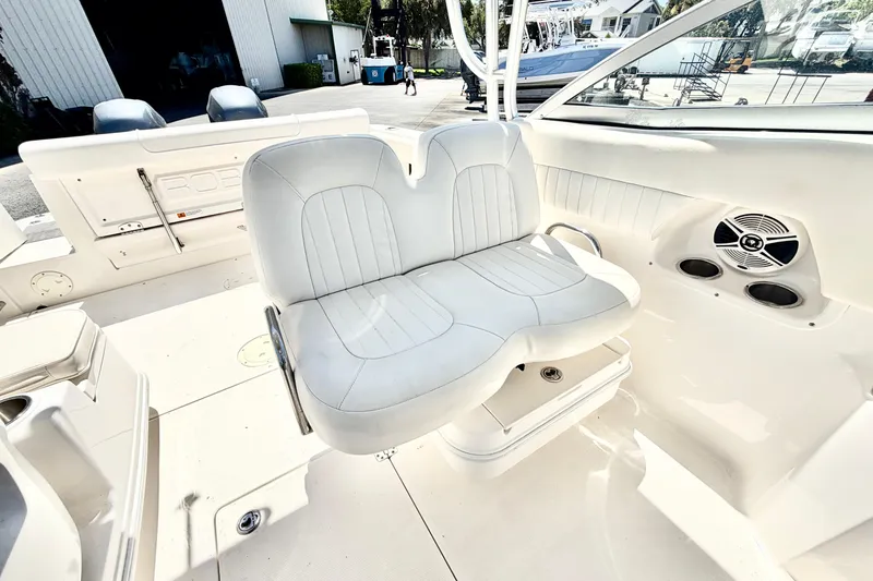 Slide: The Image of 2012 Robalo R247 Dual Console boat interior with white seating and speaker system. - 18
