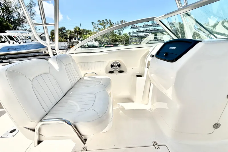 Slide: The Image of 2012 Robalo R247 Dual Console boat interior with white seating and dashboard. - 19