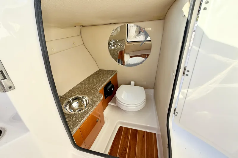 Slide: The Image of 2012 Robalo R247 Dual Console boat interior with toilet and sink. - 21