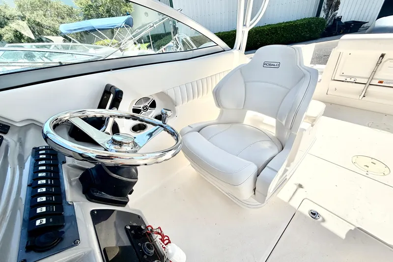 Slide: The Image of 2012 Robalo R247 Dual Console boat interior with steering wheel and captain's chair. - 24