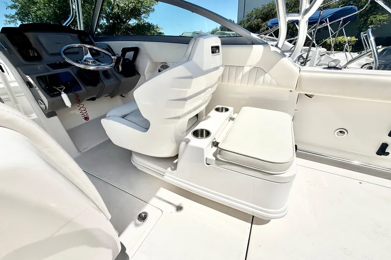 Slide: The Image of 2012 Robalo R247 Dual Console boat interior with helm, seating, and cup holders. - 25