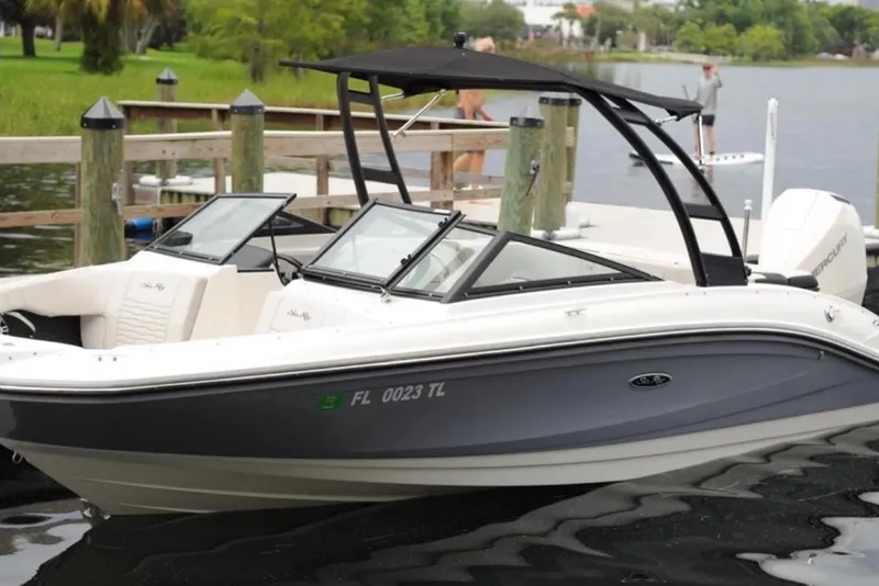 The Image of A 2023 Sea Ray SPX 210 Outboard is docked at a calm pier. It features a sleek design. - 0