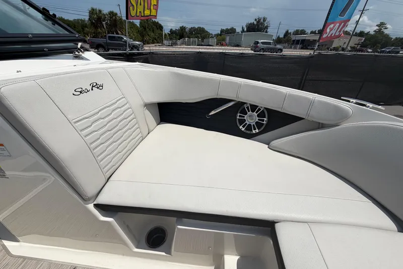 Slide: The Image of 2023 Sea Ray SPX 210 Outboard boat interior with white seating and speaker detail. - 29