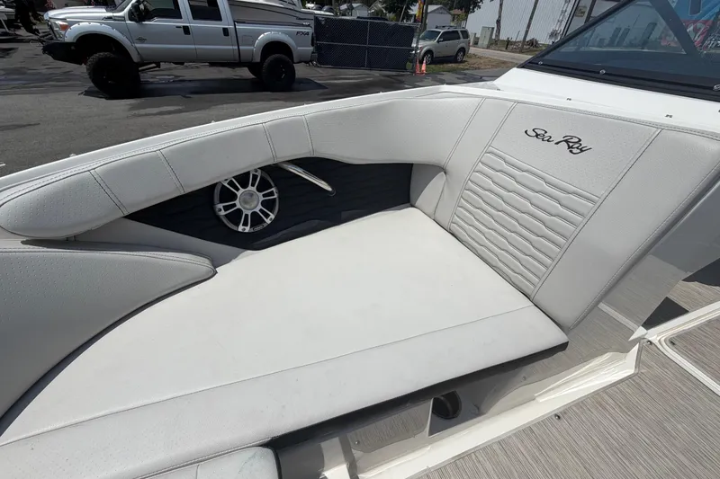 Slide: The Image of 2023 Sea Ray SPX 210 Outboard boat interior with white cushioned seating. - 32