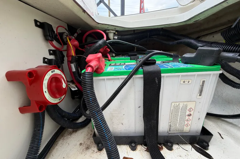 Slide: The Image of Battery compartment of 2023 Sea Ray SPX 210 Outboard with wiring and power switch. - 60