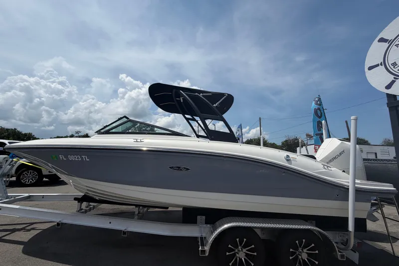 Slide: The Image of 2023 Sea Ray SPX 210 Outboard boat on trailer under a clear blue sky. - 6