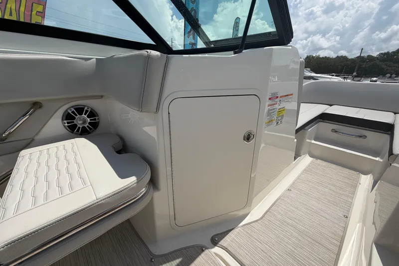 Slide: The Image of 2023 Sea Ray SPX 210 Outboard interior with seating, speaker, and storage compartment. - 23
