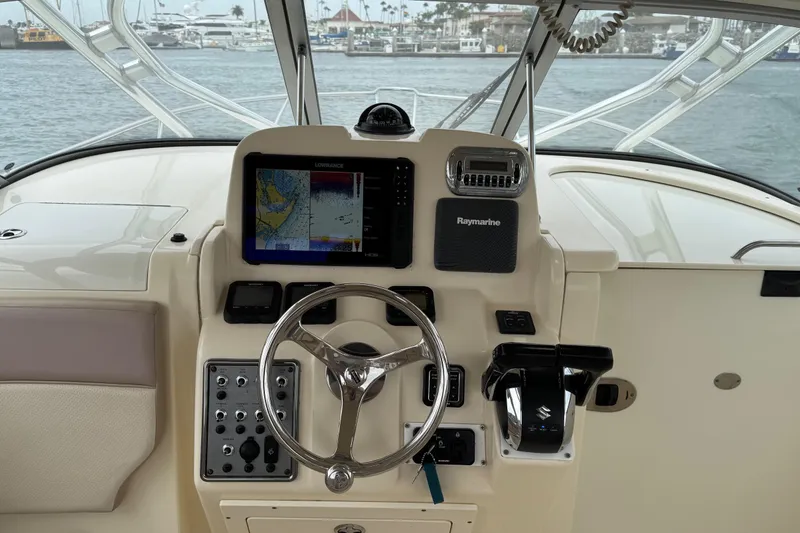 Slide: The Image of 2008 Scout 295 Abaco boat dashboard with navigation equipment and steering wheel. - 10