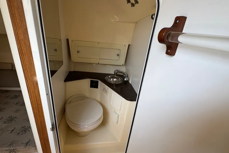 Slide: The Image of Compact bathroom in 2008 Scout 295 Abaco boat, featuring toilet and sink. - 30