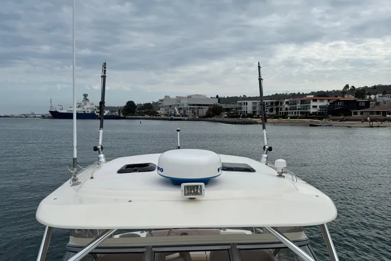 Slide: The Image of 2008 Scout 295 Abaco boat docked near coastal buildings under cloudy sky. - 17
