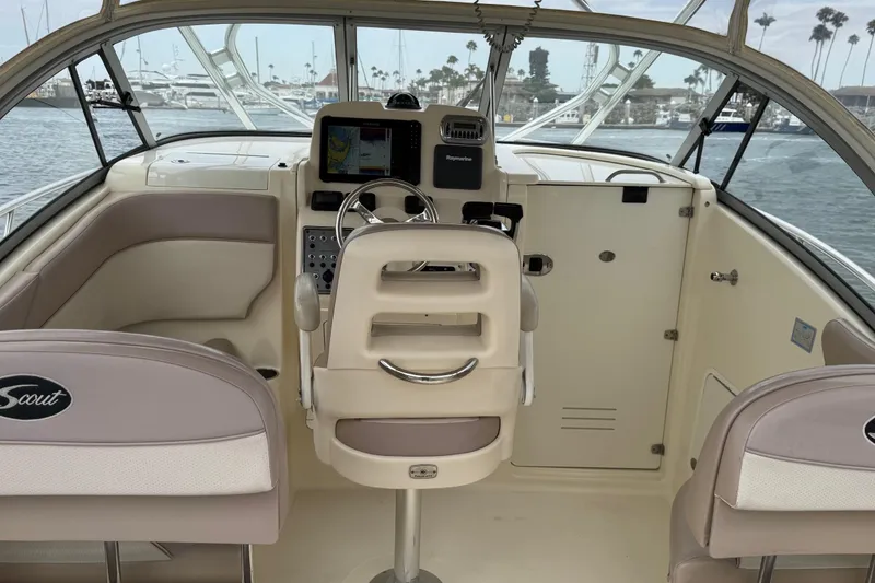 Slide: The Image of 2008 Scout 295 Abaco boat interior with helm, steering wheel, and navigation system. - 12