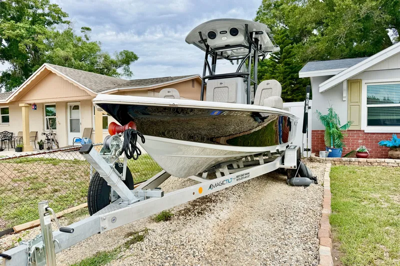 Slide: The Image of 2025 Sea Pro 230 Bay boat on trailer, parked in residential driveway. - 2