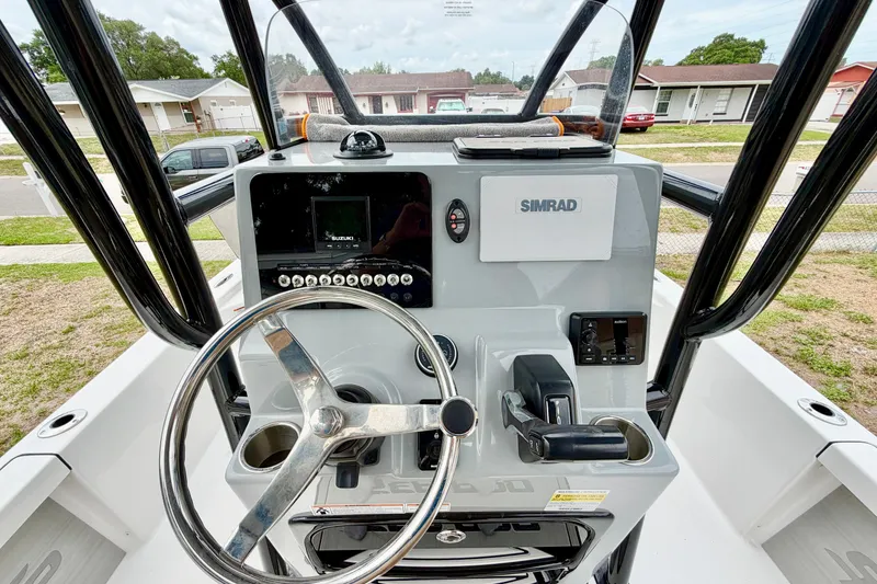 Slide: The Image of 2025 Sea Pro 230 Bay boat dashboard with steering wheel and Simrad electronics. - 4