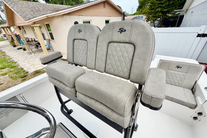 Slide: The Image of Two cushioned seats with quilted pattern on a boat, surrounded by a residential area. - 5