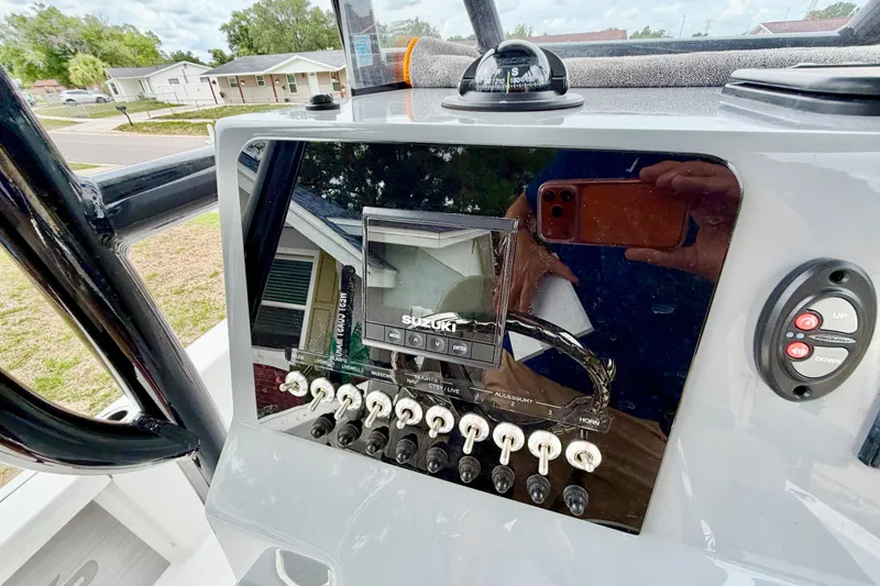 Slide: The Image of 2025 Sea Pro 230 Bay boat dashboard with Suzuki display and control switches. - 7