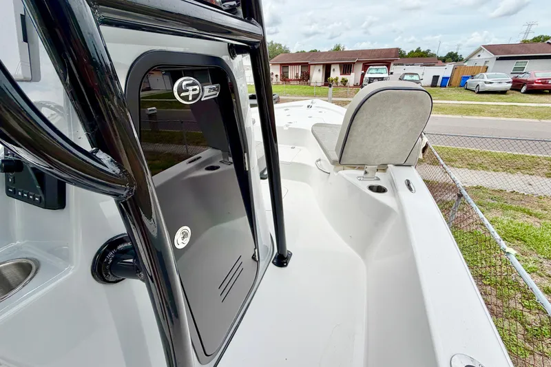 Slide: The Image of 2025 Sea Pro 230 Bay boat interior with seating and storage, parked in a residential area. - 8
