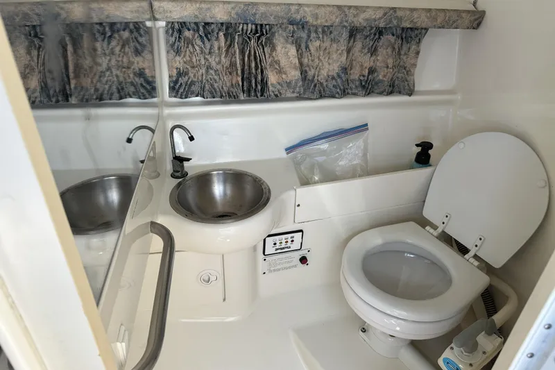 Slide: The Image of Compact bathroom in a 2000 Formula 280 Sun Sport boat, featuring a sink and toilet. - 11