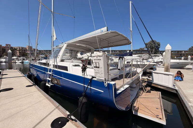 Slide: The Image of 2022 Beneteau Oceanis Yacht 54 docked at marina, featuring sleek blue hull and spacious deck. - 10