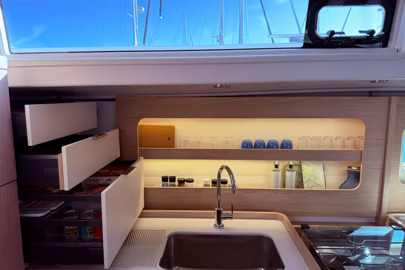 Slide: The Image of Luxurious kitchen interior of 2022 Beneteau Oceanis Yacht 54 with modern cabinetry and sink. - 52