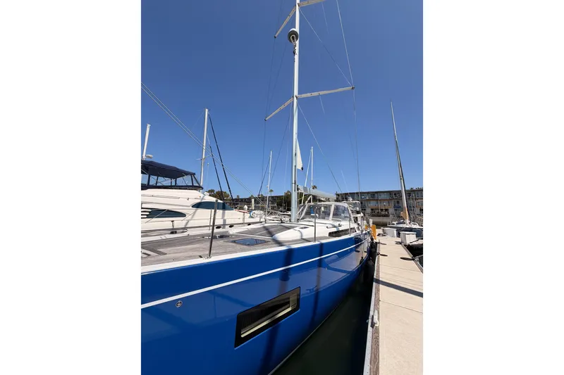 Slide: The Image of 2022 Beneteau Oceanis Yacht 54 docked, showcasing sleek blue hull and modern design. - 6