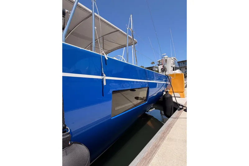 Slide: The Image of 2022 Beneteau Oceanis Yacht 54 with sleek blue hull docked at marina. - 9