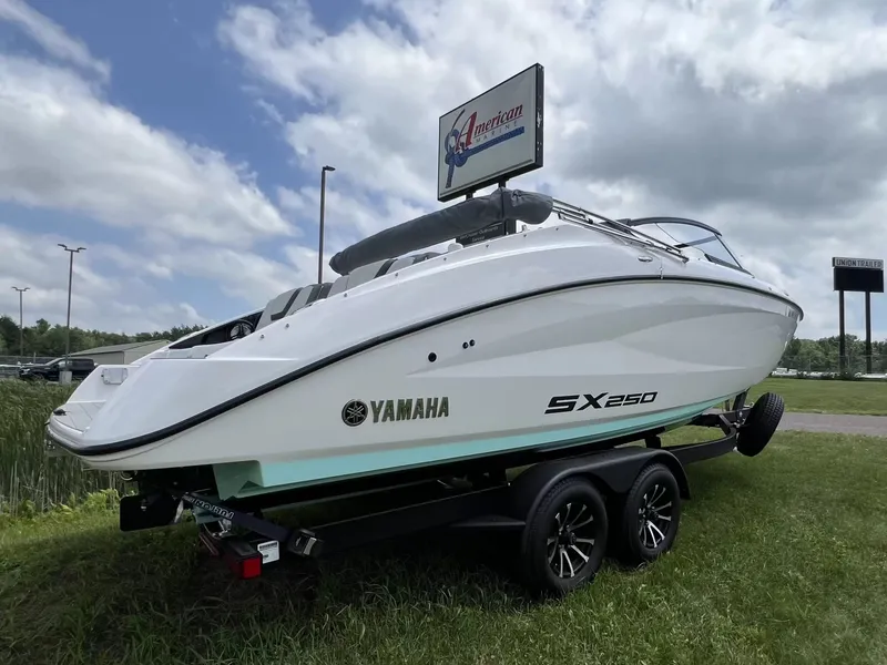 Slide: The Image of Yamaha SX250 boat on a trailer on grass under a cloudy sky. - 2