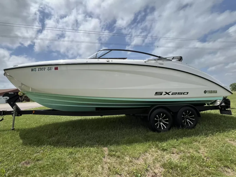 Slide: The Image of A 2023 Yamaha SX250 boat on a trailer, parked on grass. - 5
