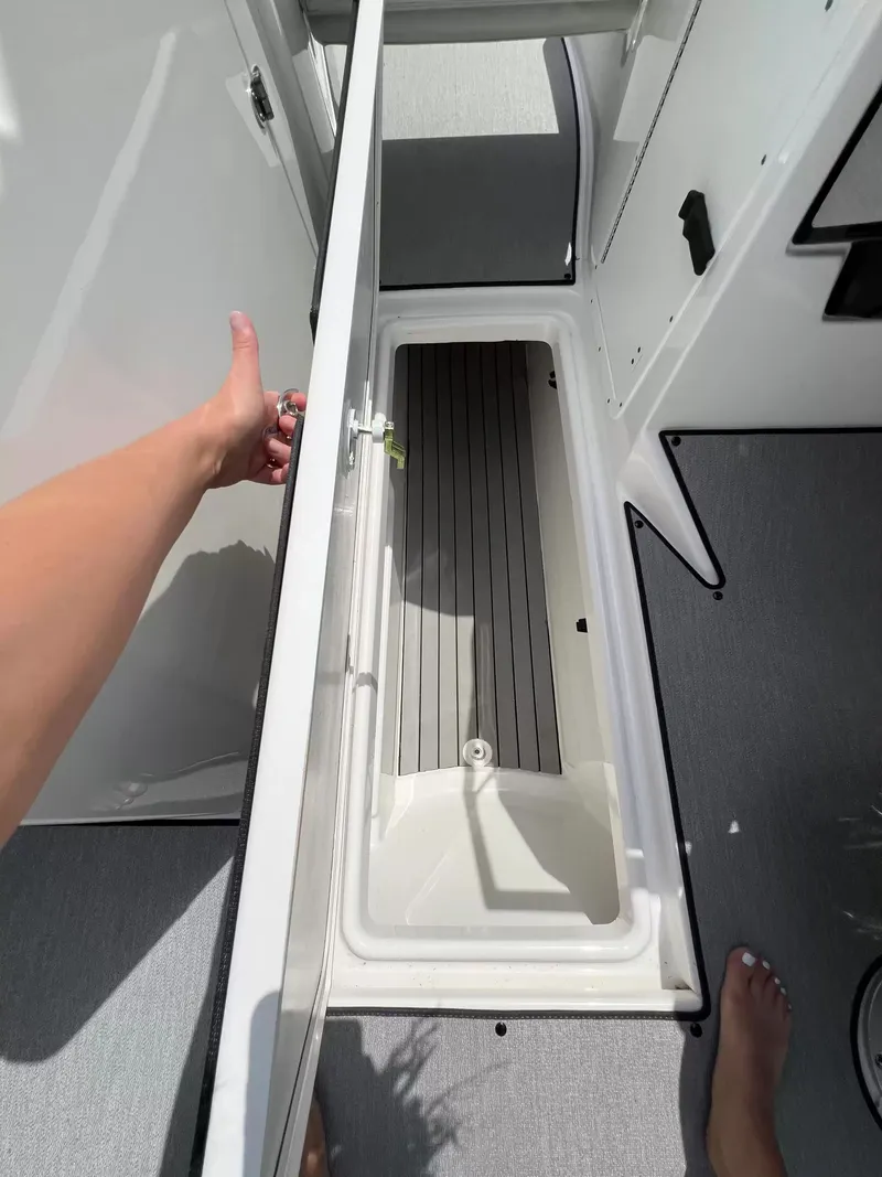 Slide: The Image of An open storage compartment on a 2023 Yamaha SX250 boat. - 12