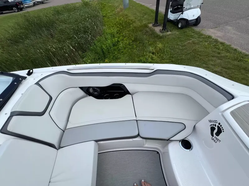 Slide: The Image of The image shows the seating area of a 2023 Yamaha SX250 boat with white upholstery. - 8