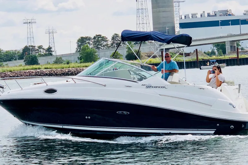 The Image of 2006 Sea Ray 240 Sundancer cruising on a river with two passengers onboard. - 0