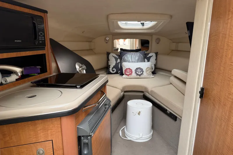 Slide: The Image of Interior of 2006 Sea Ray 240 Sundancer boat with cozy seating and kitchenette. - 12
