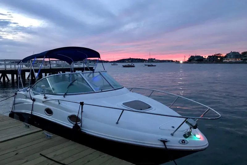 Slide: The Image of 2006 Sea Ray 240 Sundancer docked at sunset, calm waters, scenic view. - 2