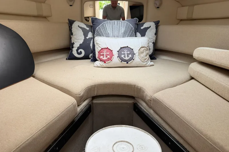 Slide: The Image of Interior of 2006 Sea Ray 240 Sundancer with nautical-themed cushions and beige seating. - 13