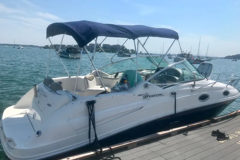 Slide: The Image of 2006 Sea Ray 240 Sundancer docked, featuring a blue canopy and sleek design. - 3