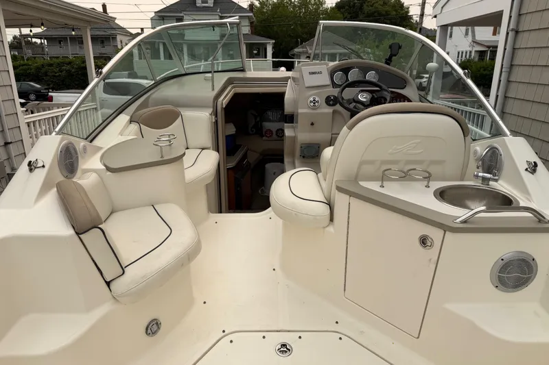 Slide: The Image of 2006 Sea Ray 240 Sundancer boat interior with seating, steering wheel, and sink. - 4