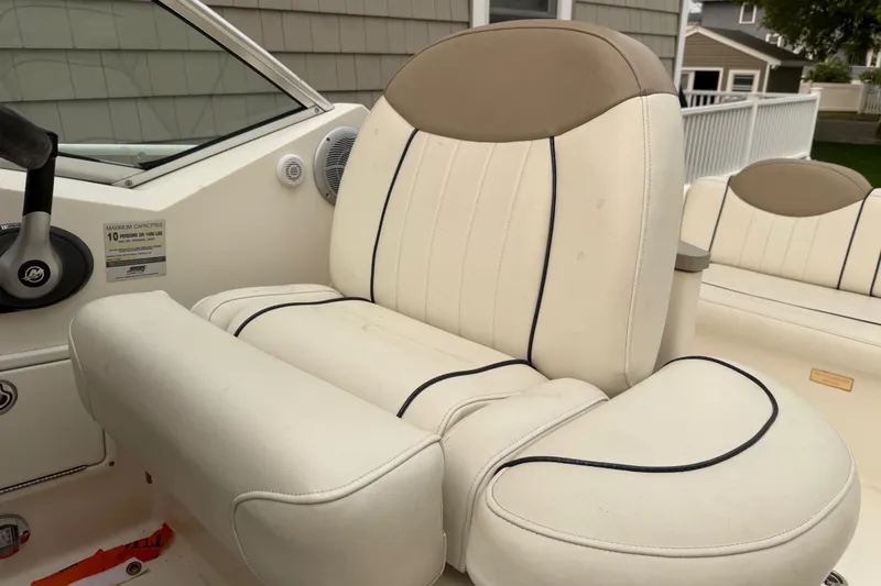 Slide: The Image of 2006 Sea Ray 240 Sundancer boat interior with beige captain's seat and steering wheel. - 9