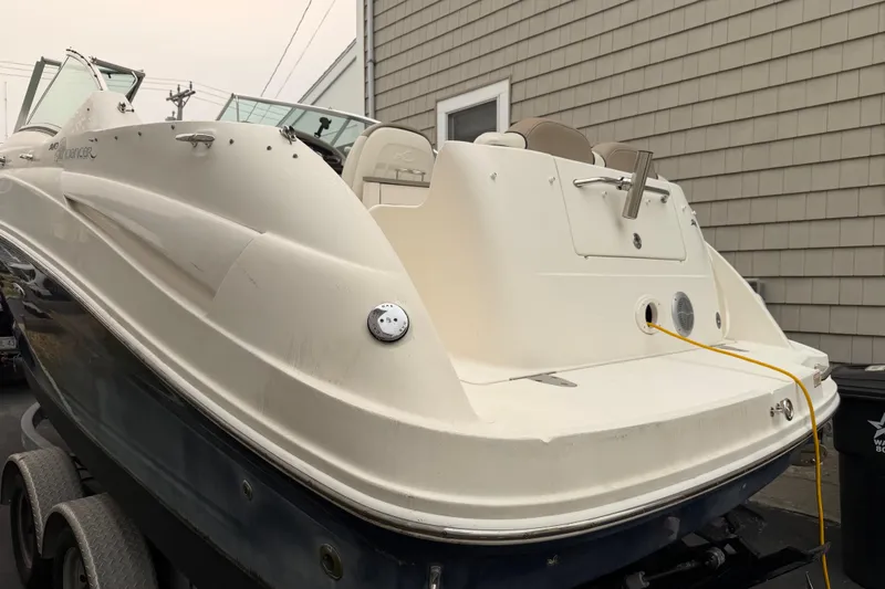 Slide: The Image of 2006 Sea Ray 240 Sundancer boat on trailer, parked beside a building. - 3